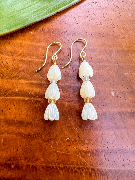 Pair of 3 carved MOP pikake bud bead swith citrine & moonstone  rondels on monkey pod background